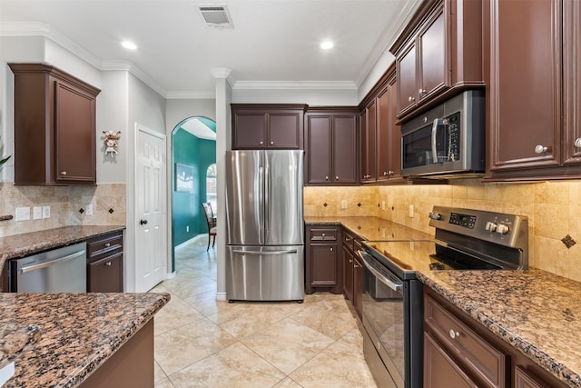 kitchen with light tile patterned floors, stainless steel appliances, crown molding, and dark stone counters