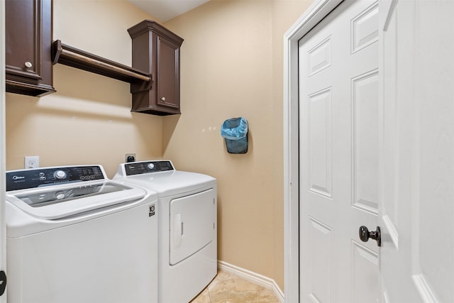 laundry room featuring light tile patterned floors, washing machine and dryer, and cabinets