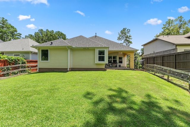 back of house featuring a lawn and a patio