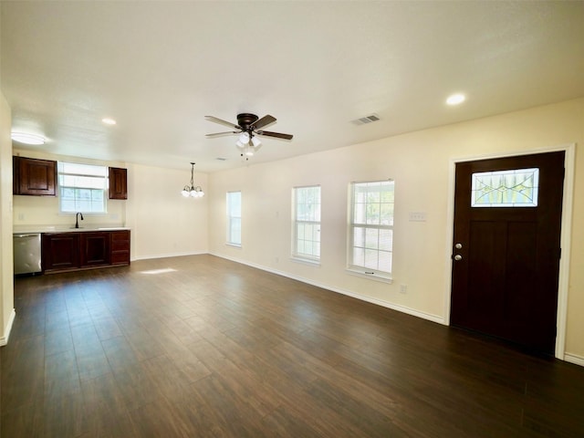 unfurnished living room featuring a chandelier, ceiling fan, dark wood-style floors, baseboards, and recessed lighting