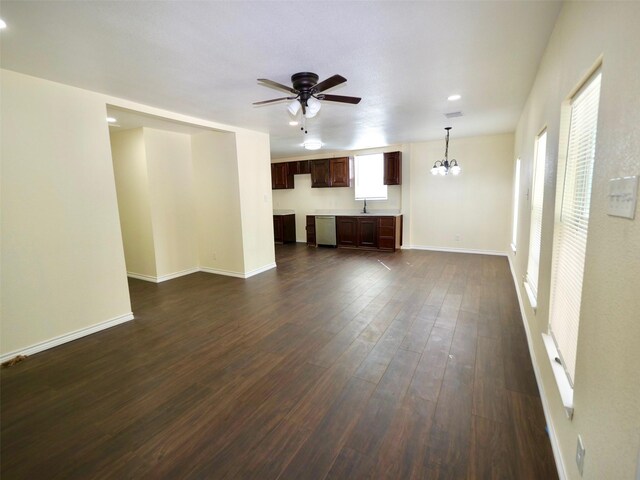 unfurnished living room with dark wood-style floors, ceiling fan, a chandelier, a sink, and baseboards