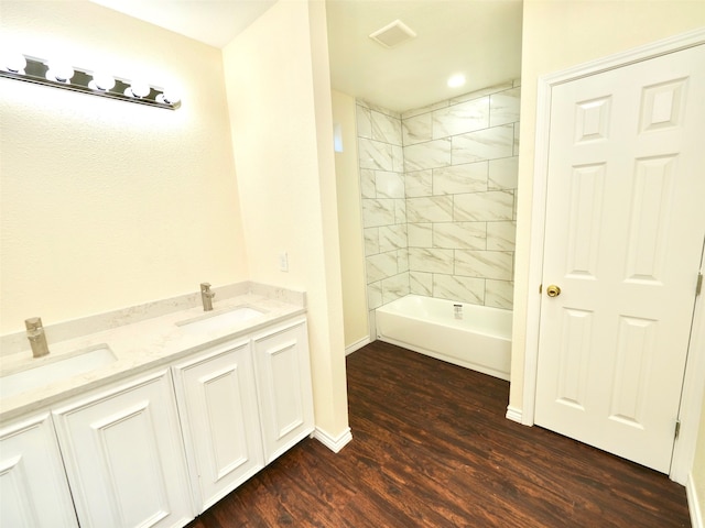 bathroom featuring vanity, hardwood / wood-style floors, and tiled shower / bath combo