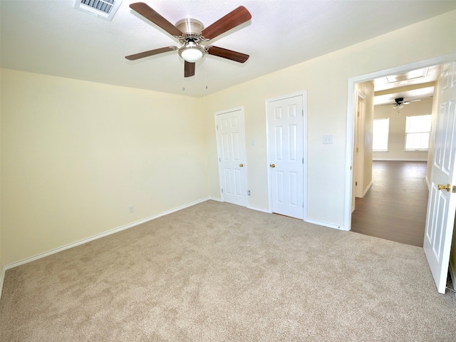 unfurnished bedroom featuring light colored carpet and ceiling fan