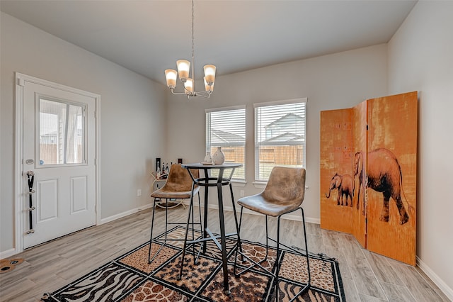 dining space with an inviting chandelier and light hardwood / wood-style flooring