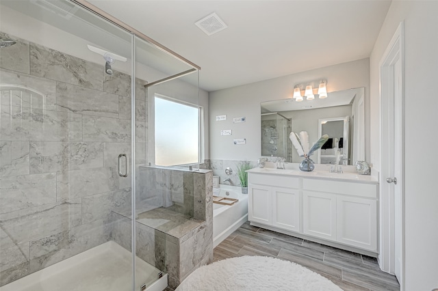 bathroom with hardwood / wood-style floors, vanity, and separate shower and tub