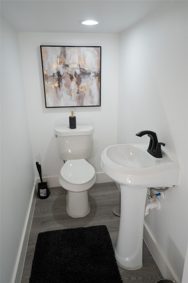 bathroom with toilet and hardwood / wood-style flooring