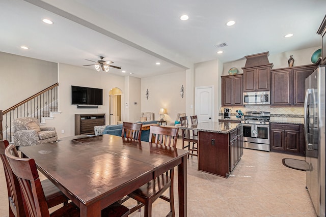 tiled dining space with ceiling fan