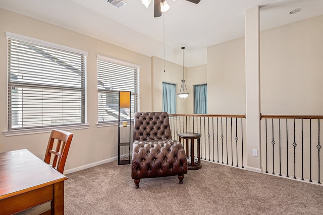 sitting room with ceiling fan and carpet