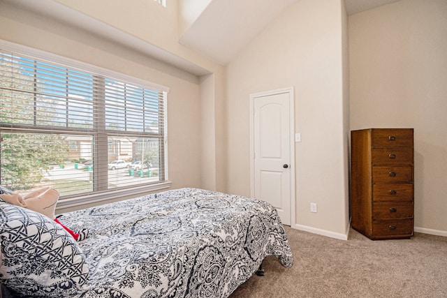 bedroom with light colored carpet and high vaulted ceiling