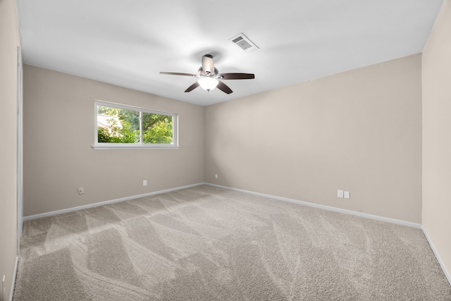 carpeted spare room featuring ceiling fan