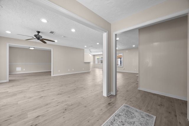 unfurnished living room featuring light hardwood / wood-style floors, ceiling fan, and a textured ceiling