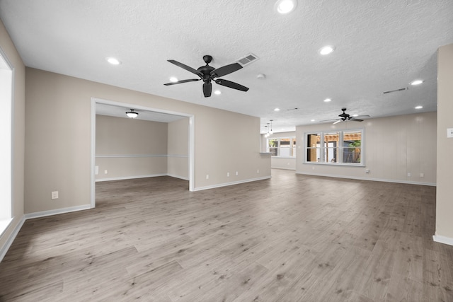 unfurnished living room with ceiling fan, a textured ceiling, and light wood-type flooring