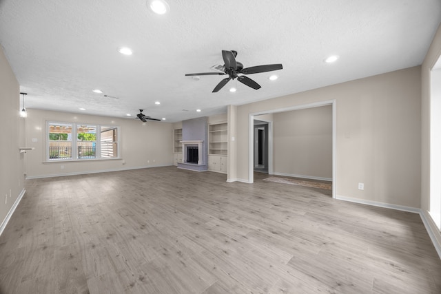 unfurnished living room featuring light wood-type flooring, a textured ceiling, and ceiling fan