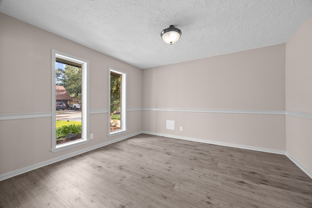 spare room with a textured ceiling and hardwood / wood-style floors