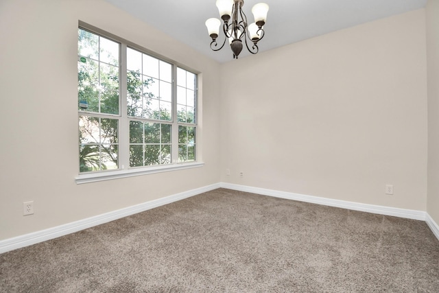 unfurnished room with carpet and a chandelier