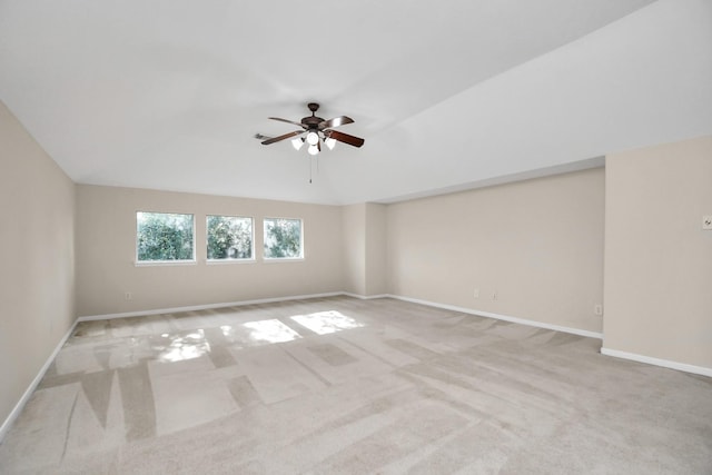 carpeted empty room with ceiling fan and lofted ceiling