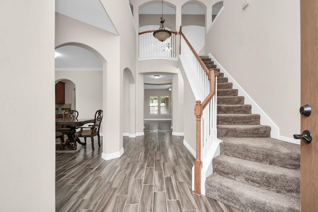 entrance foyer featuring hardwood / wood-style flooring, ornamental molding, and a high ceiling