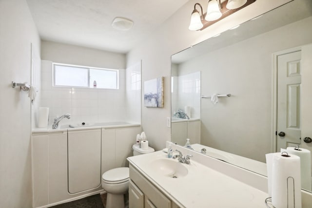 bathroom with vanity, a washtub, and toilet