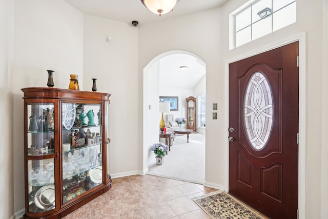 entrance foyer featuring lofted ceiling and light tile patterned floors