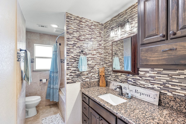 full bathroom with vanity, tasteful backsplash, shower / bath combo, tile walls, and toilet