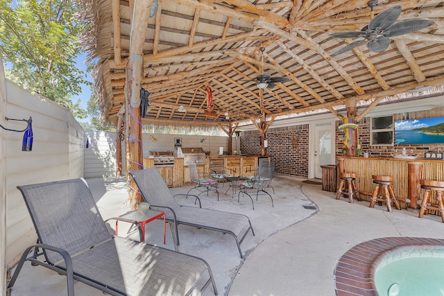 view of patio / terrace with grilling area, a jacuzzi, exterior bar, and ceiling fan