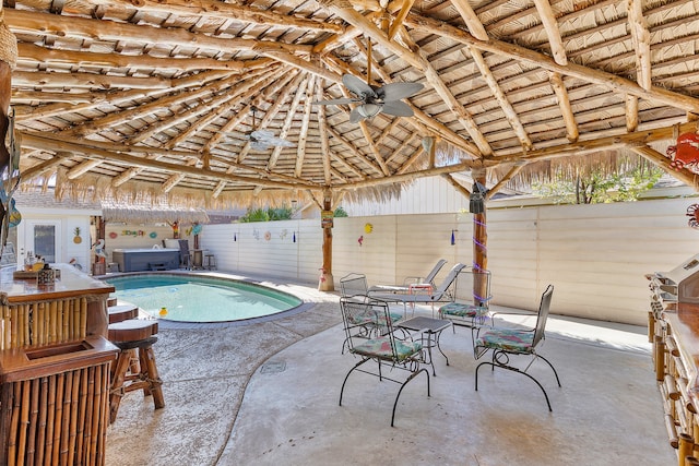 view of swimming pool featuring ceiling fan, a patio area, and a jacuzzi