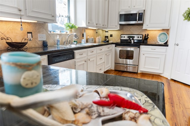 kitchen with white cabinets, stainless steel appliances, and tasteful backsplash