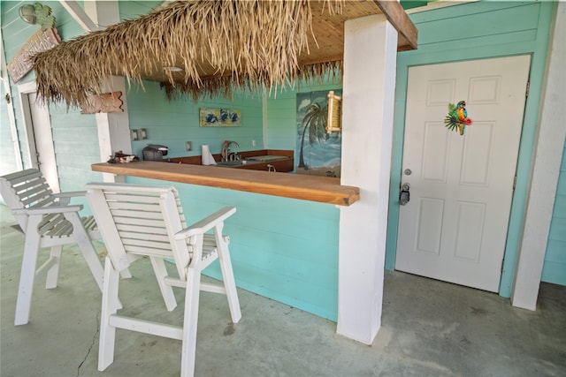 bar with concrete flooring and wooden walls