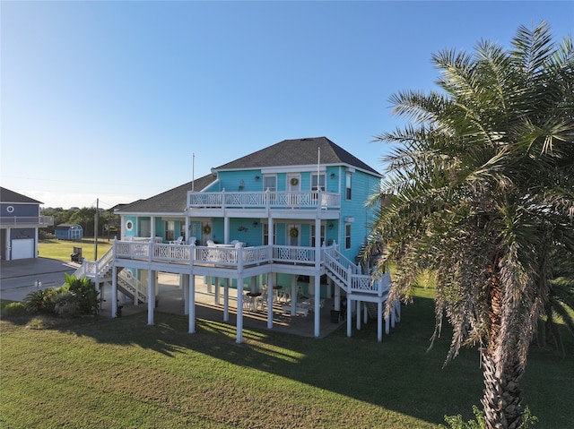 back of property featuring covered porch, a lawn, and a garage