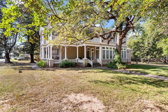 back of property with a lawn and covered porch