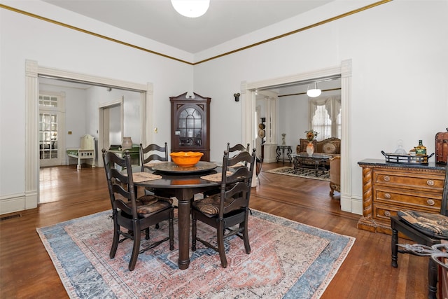 dining area featuring dark hardwood / wood-style floors and crown molding