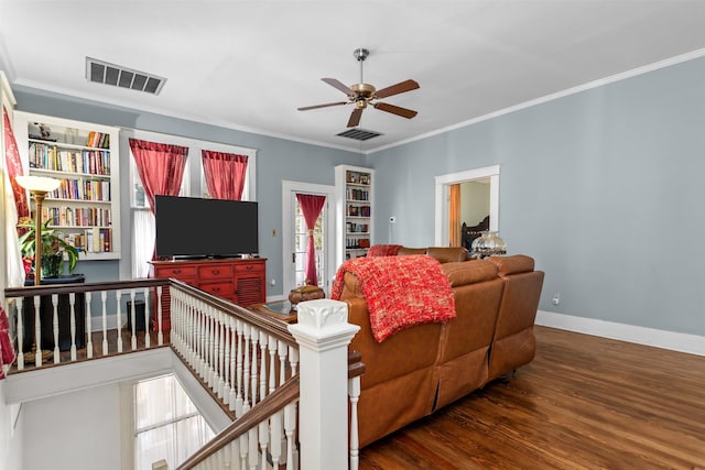 living room with ceiling fan, ornamental molding, plenty of natural light, and dark wood-type flooring