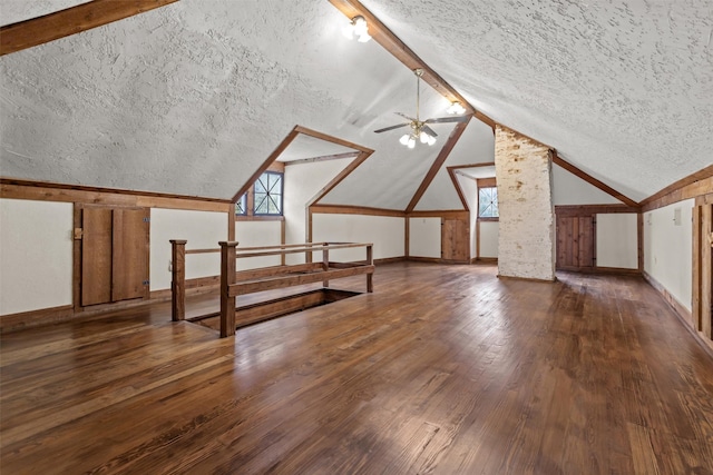 bonus room featuring lofted ceiling with beams, ceiling fan, a textured ceiling, and dark wood-type flooring