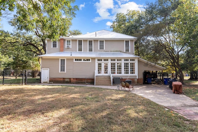 rear view of house with central AC unit and a yard