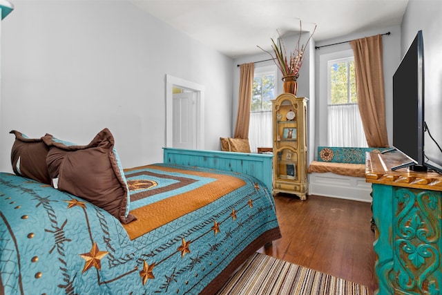 bedroom with dark hardwood / wood-style flooring