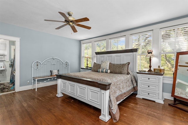 bedroom with ceiling fan, ensuite bathroom, multiple windows, and dark hardwood / wood-style flooring