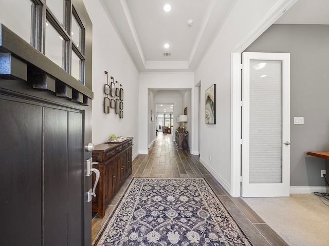 hallway featuring a raised ceiling and dark wood-type flooring