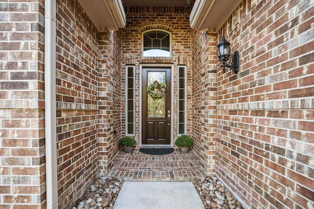 doorway to property with brick siding