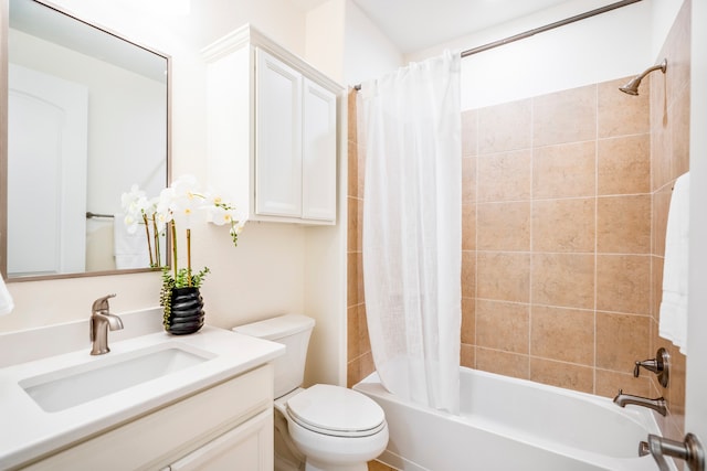 full bathroom with vanity, shower / tub combo with curtain, and toilet