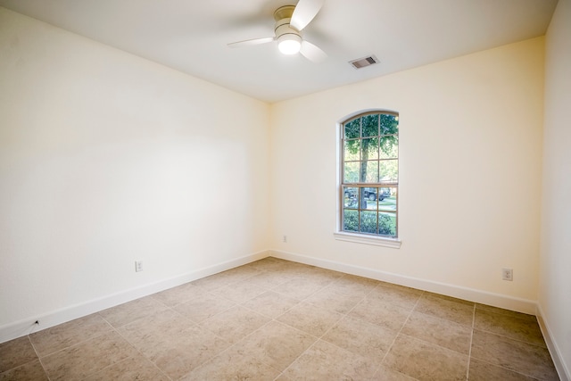 unfurnished room with a ceiling fan, visible vents, and baseboards