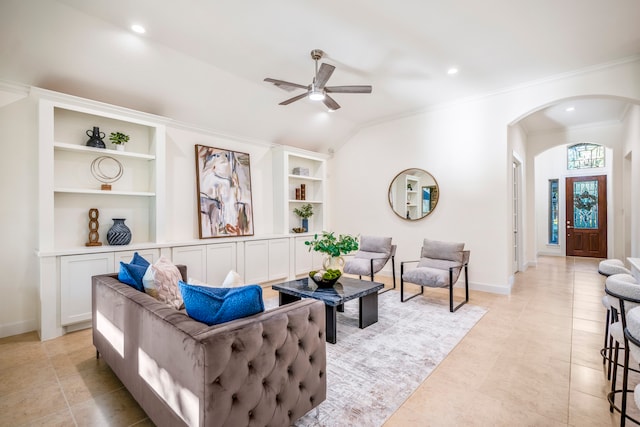 tiled living room with ceiling fan, lofted ceiling, crown molding, and built in features