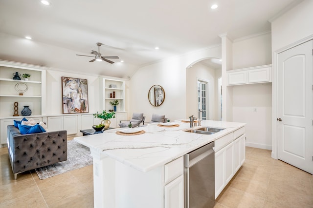 kitchen with light stone counters, a kitchen island with sink, sink, and dishwasher