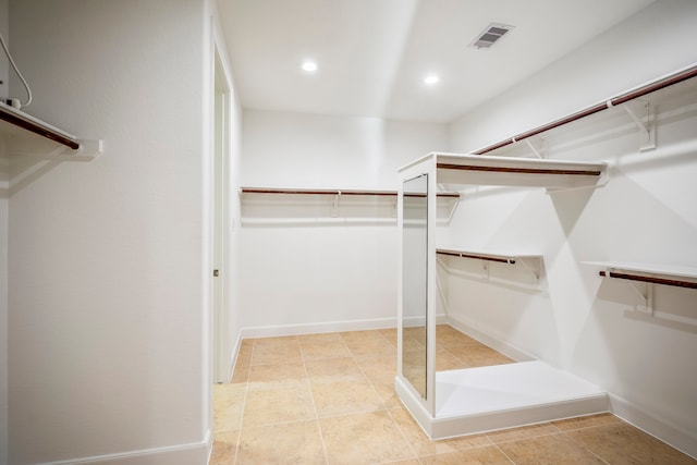 walk in closet with light tile patterned floors