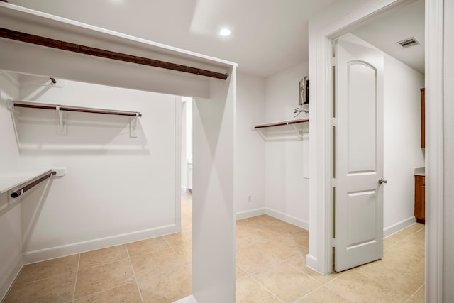 walk in closet with light tile patterned floors