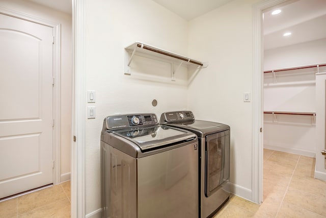 washroom featuring washer and clothes dryer and light tile patterned floors