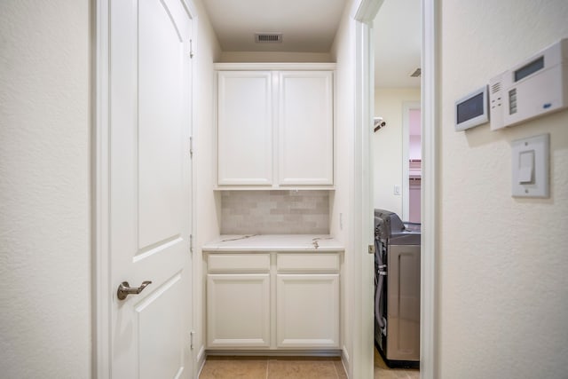 interior space featuring white cabinets, visible vents, light countertops, and backsplash