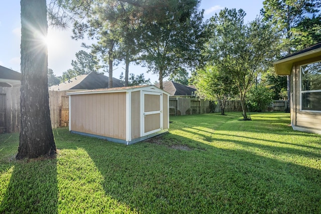 view of yard featuring an outbuilding, a storage unit, and a fenced backyard