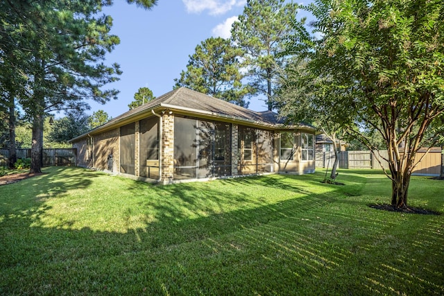 view of yard with a sunroom and a fenced backyard