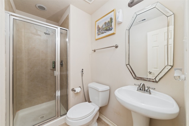 bathroom with a textured ceiling, sink, an enclosed shower, and toilet