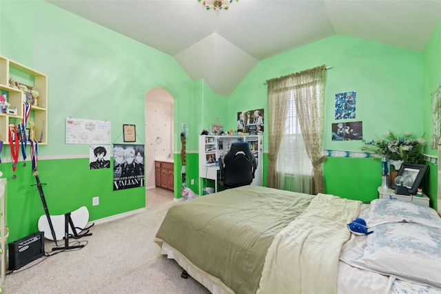 bedroom with lofted ceiling, ensuite bath, and carpet flooring